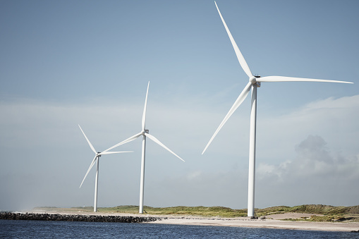 Still life shot of wind turbines along the beachfront