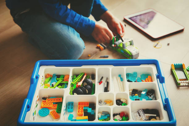 istock teenage boy building from colorful plastic blocks 869222212