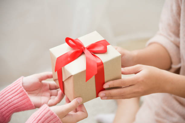 istock Asian woman hands giving a brown gift box. 869225780