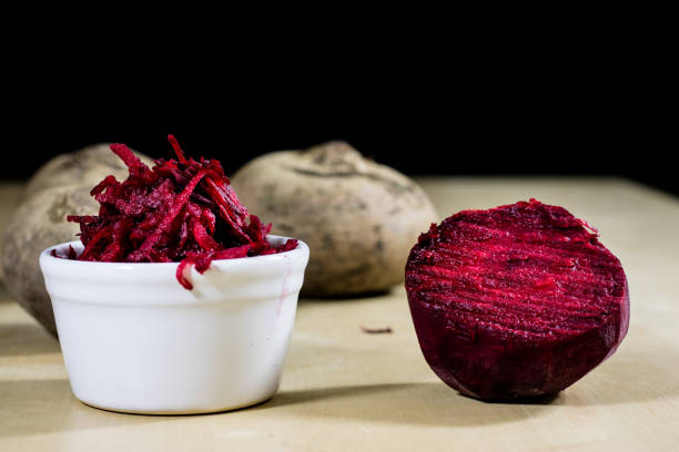 istock Beetroots grated on shavings. Wooden dining table. Black background. 869226264