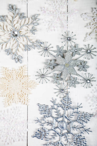 istock Silvery snowflakes on a wooden background 869226278