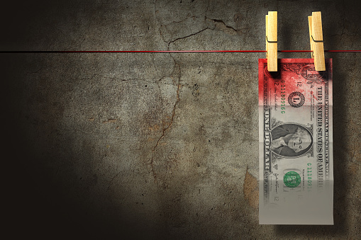 3D illustration. A blood stained dollar bill hung up to dry. Money laundry concept.