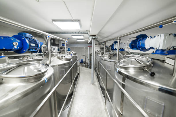 A long gangway between two rows of cisterns. Storage of food liquids A long gangway between two rows of cisterns. Stainless steel. Storage of food liquids. nuclear reactor stock pictures, royalty-free photos & images