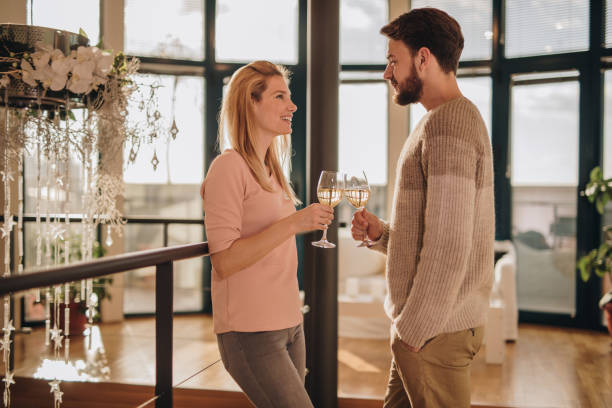 istock Young happy couple talking while toasting with wine at home. 869231904