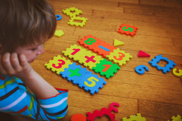 istock little boy playing with puzzle, education concept 869234108