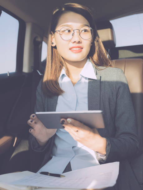 istock young businesswoman using tablet on car backseat 869241170