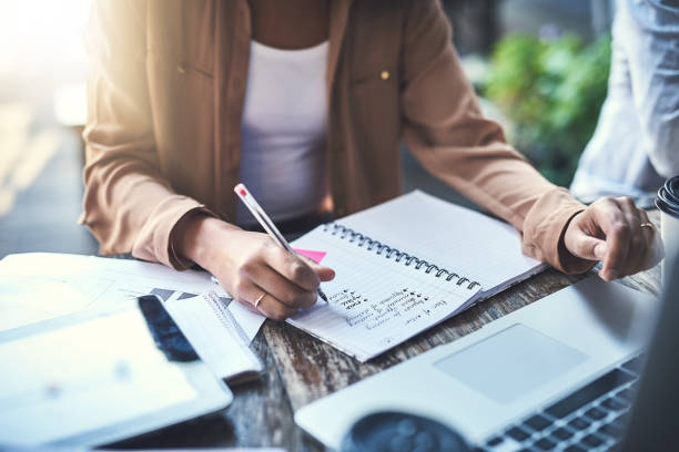 Figuring out their next plan of action Closeup shot of an unrecognisable businesswoman writing notes at a coffee shop aspirations stock pictures, royalty-free photos & images