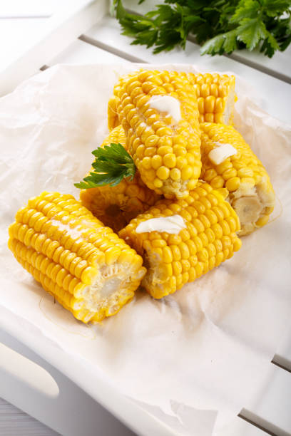 istock Boiled sweet corn cob with butter and salt on white table. 869245752