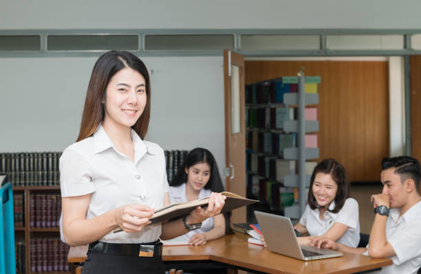 istock Portrait of cute smiling student reading book 869247266