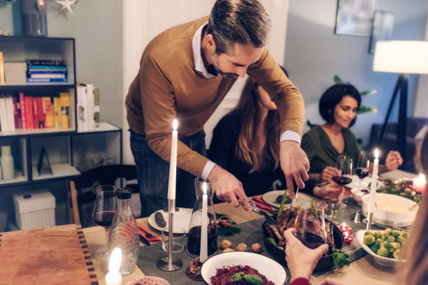 istock bearded man carving celebrity roast at christmas table 869250154