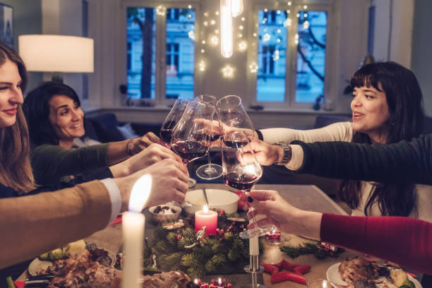 istock friends clinking wine glasses at christmas table 869250478