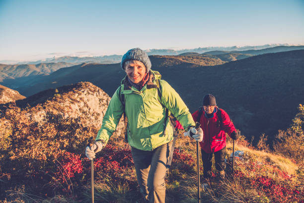 pareja senior caminatas al amanecer otoñal en meridional montan@as julian, europa - senior adult fun autumn senior couple fotografías e imágenes de stock