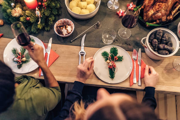 istock overhead view on people at festive decorate christmas table 869251054