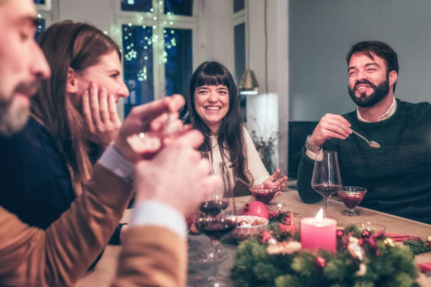istock young happy people talking at christmas table 869253808