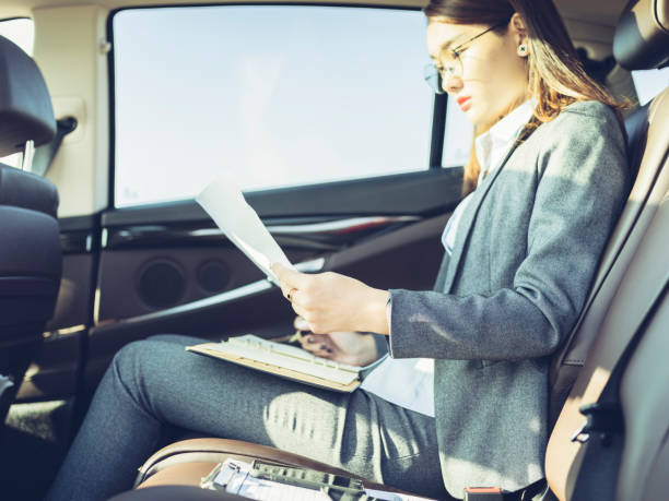 istock business woman working in car with paperwork 869257172