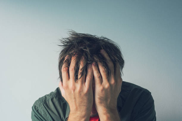 Disappointed man crying with head in hands Disappointed man crying with head in hands. Sad and lonely adult male hiding tears. head in hands stock pictures, royalty-free photos & images