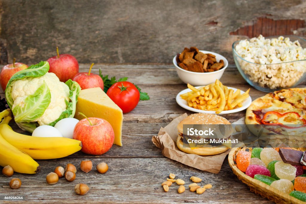 Fastfood und gesundes Essen auf alten hölzernen Hintergrund. Konzept, die Auswahl der richtigen Ernährung oder Junk-Essen. - Lizenzfrei Ungesunde Ernährung Stock-Foto