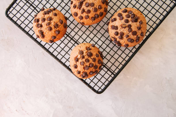 istock Chocolate chip cookies on a wire rack on white stone background 869261992