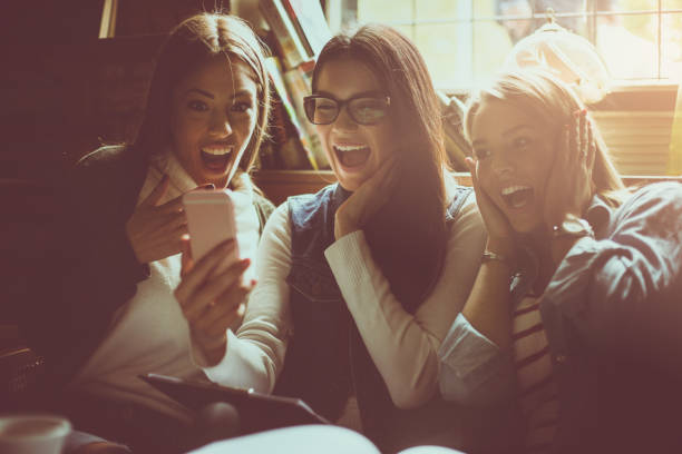 istock Cheerful students girl sitting in library and using mobile phone together. Close up. 869262664