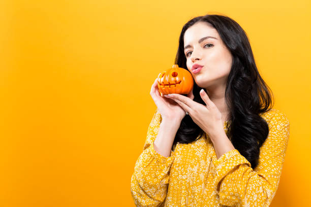 giovane donna che tiene in mano una zucca - pumpkin small orange holiday foto e immagini stock