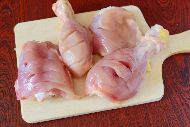 istock Skinless chicken thighs on a wooden cutting board. 869266616
