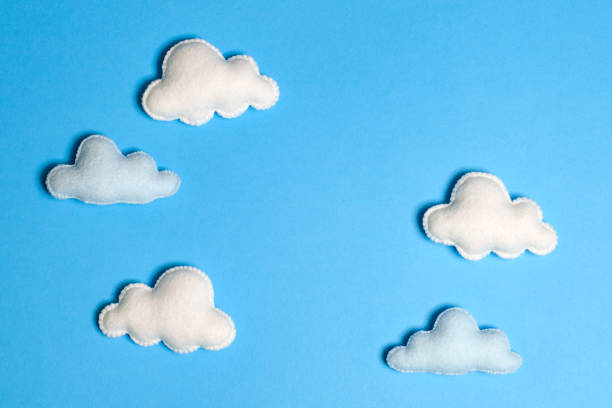 istock Craft white clouds in blue sky with frame, copyspace. Hand made felt toys. Abstract sky. 869278922