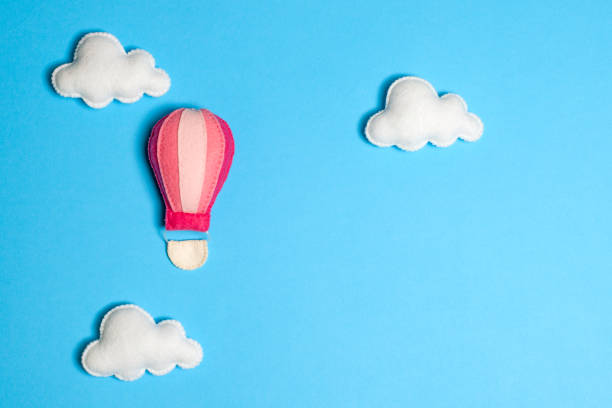 istock Hot air balloon in blue sky with clouds, frame, copyspace. Hand made felt toys. 869278962