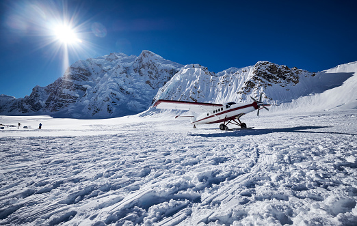 Snow Plane Landing on Ruth Glacier in Denali National Park. On a beautiful sunny day with the mountains in de background.