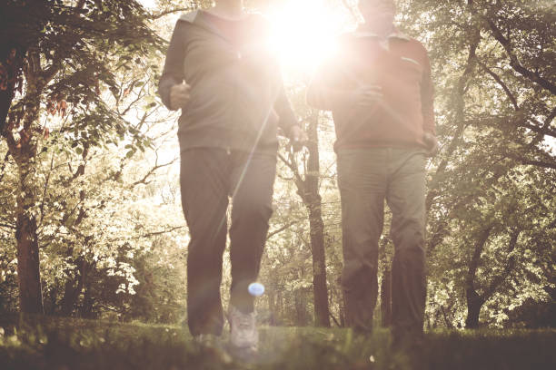 istock Active senior couple jogging together in park. Close up. 869281916