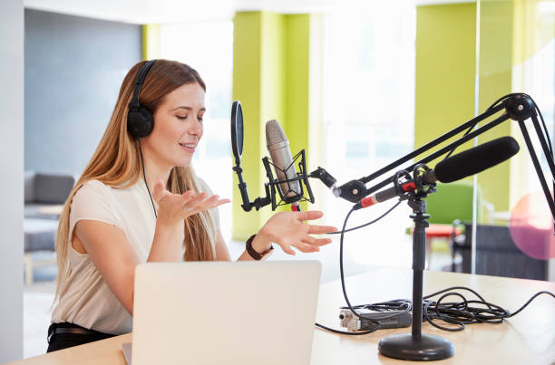 istock Young woman broadcasting in a studio gesturing, close up 869282394