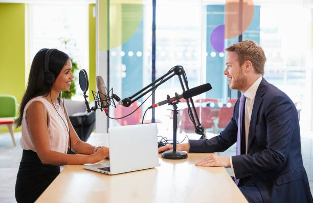 istock Young woman interviewing a guest in a studio for a podcast 869282468