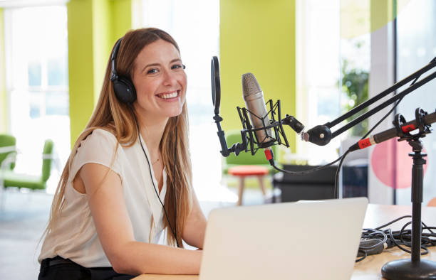 istock Young woman broadcasting in a studio smiling to camera 869282484
