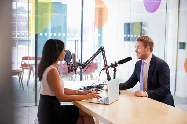 istock Young woman interviewing a guest in a studio for a podcast 869282502