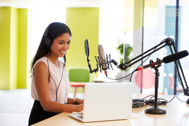 istock Young mixed race woman recording a podcast in a studio 869282538
