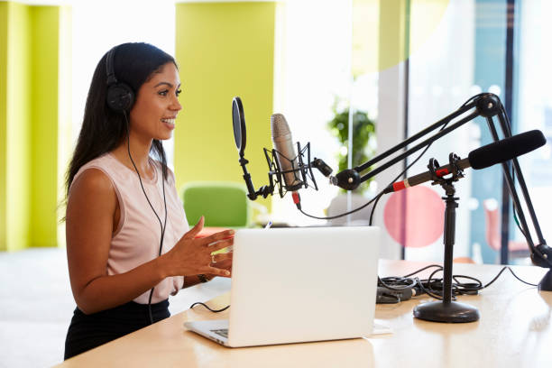 istock Young mixed race woman recording a podcast in a studio 869282570