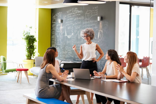 istock Female boss standing at an informal team meeting 869282722