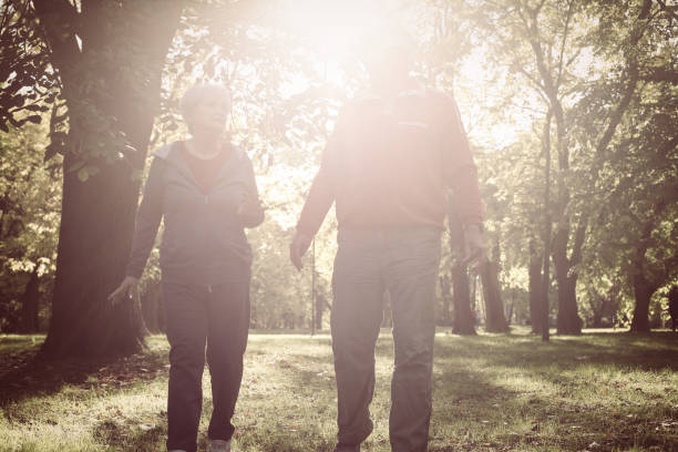 istock Active senior couple walking trough park together and having conversation. 869282728