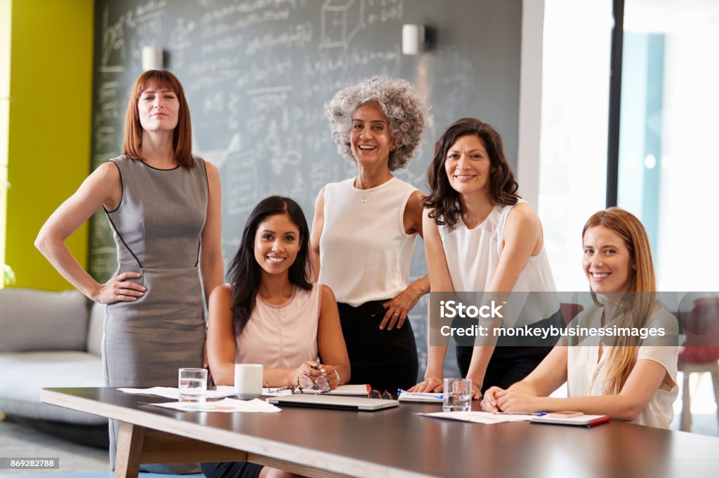 Cinq collègues féminines lors d’une réunion de travail, souriant à la caméra - Photo de Femmes libre de droits