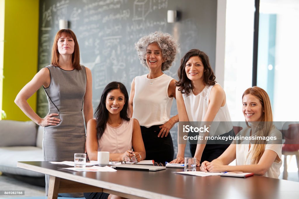 Five female colleagues at a work meeting smiling to camera Women Stock Photo