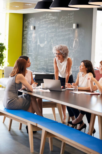 istock Informal meeting of female work colleagues, vertical 869282810