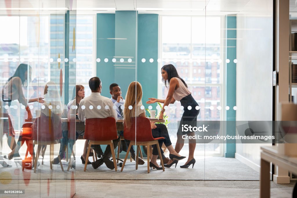 Boss femme se tient penché sur la table à la réunion d’affaires - Photo de Leadership libre de droits