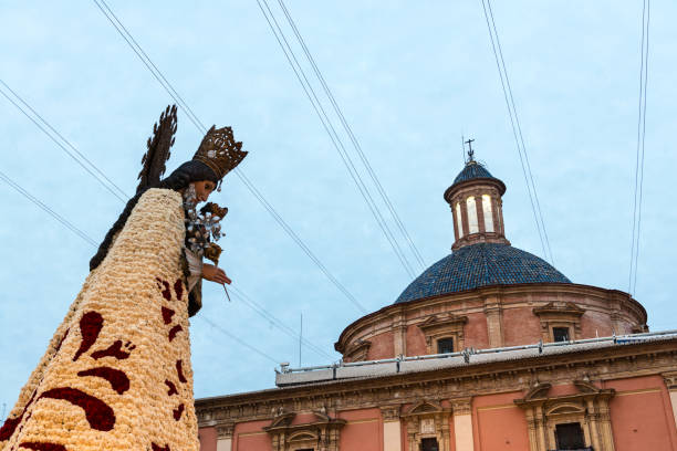 Statue of the Virgin Mary and dome of the Cathedral during the flower offering in the Fallas festival in Valencia, Spain.