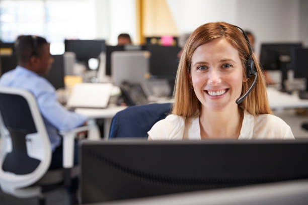 바쁜 사무실에서 헤드셋과 컴퓨터에서 일 하는 젊은 여자 - female customer service representative looking at camera technology 뉴스 사진 이미지