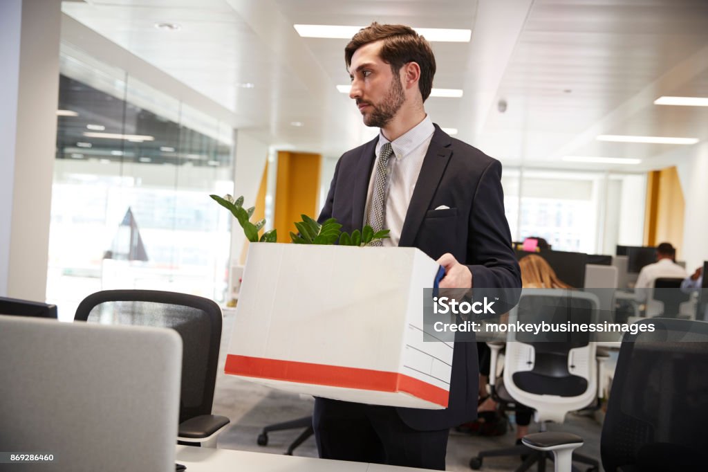 Fired male employee holding box of belongings in an office 20-29 Years Stock Photo