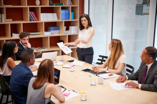 istock Female manager stands with document at boardroom meeting 869286772