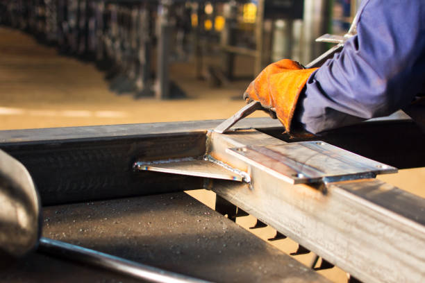 istock Worker cleaning fresh welded steel bar 869287816