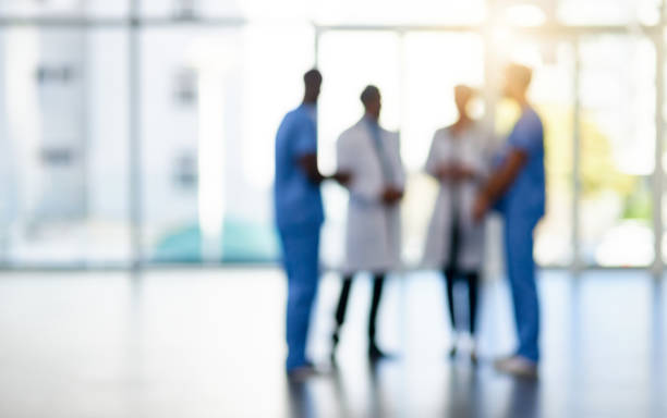 Quality care from a quality team Blurred shot of a team of doctors standing together in a hospital medical occupation stock pictures, royalty-free photos & images