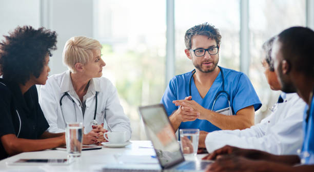 Brainstorming for the best possible diagnosis Shot of a team of doctors having a meeting in a hospital medical occupation stock pictures, royalty-free photos & images