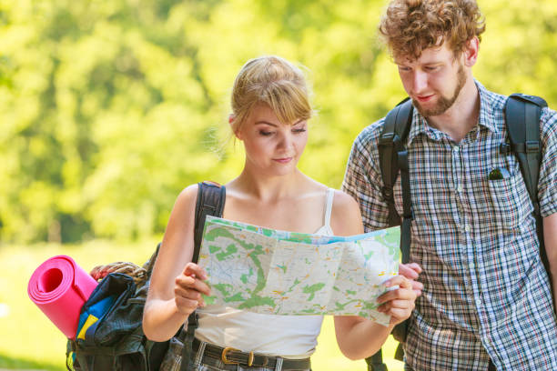 istock Hiking backpacking couple reading map on trip. 869295272