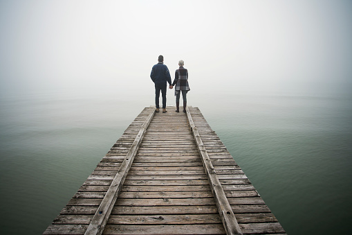 Couple at wooden foot bridge at winter day